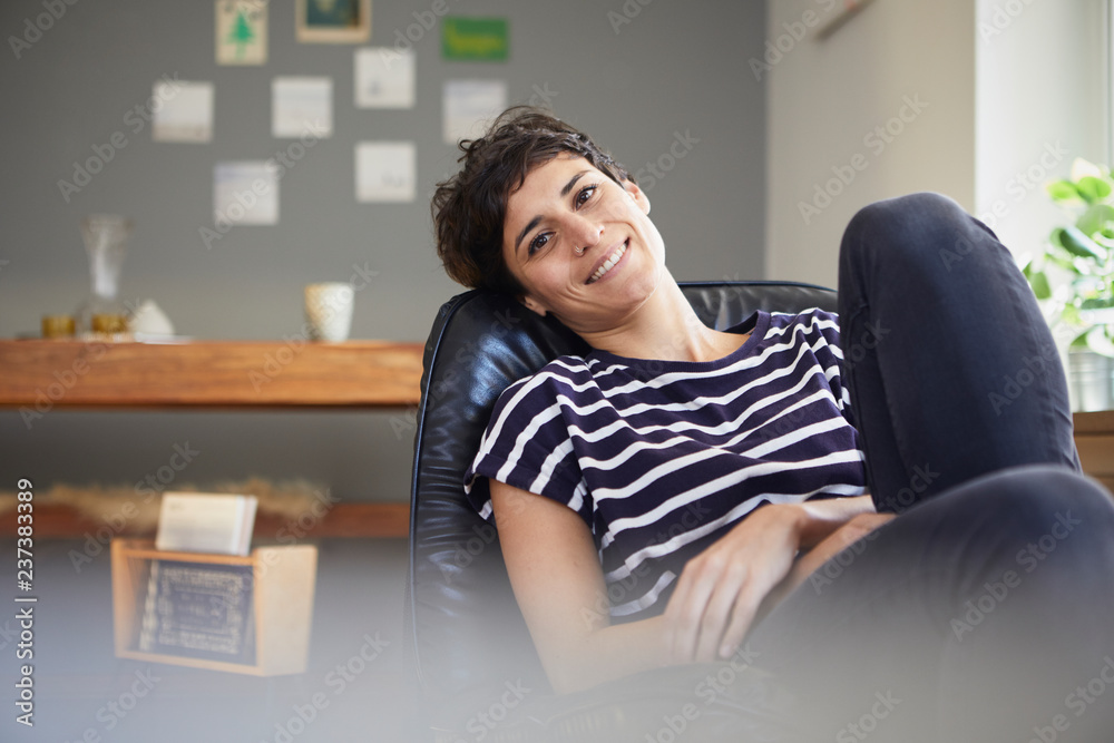 Portrait of smiling woman sitting at home relaxing Portrait of smiling woman sitting at home relaxing