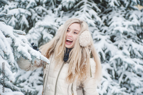 Beautiful smiling woman has a fun with snow outdoor. Lifestyle. Winter holidays.
