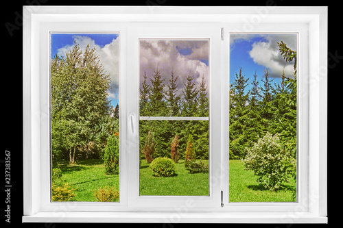 Garden view from a country house window in a sunny summer day isolated on the black