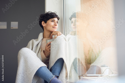 Relaxed woman at home sitting at the window photo