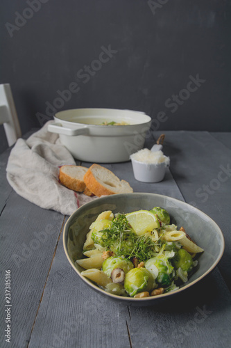 Pasta with brussels sprout, hazelnut, walnut and cress, limette soy sauce with parmesan and baguette photo