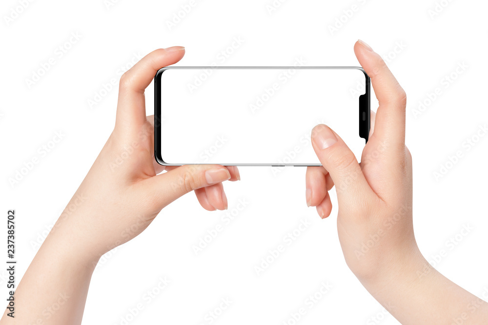 Female hands holding new modern black phone in horizontal position with empty screen on white background Female hands holding new modern black phone in horizontal position with empty screen on white background