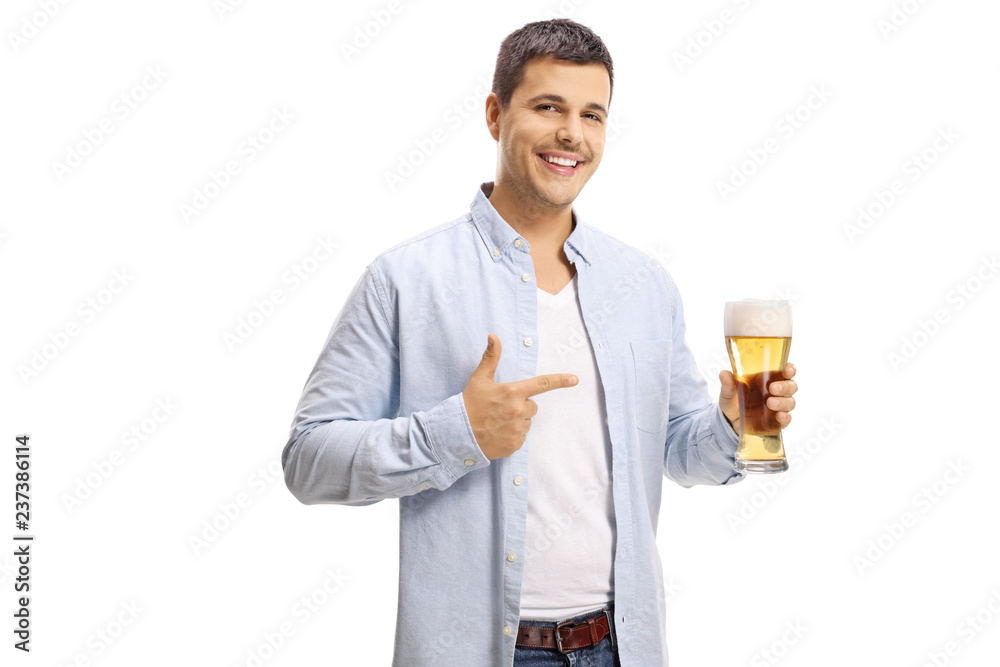 Handsome young man holding a pint of beer and pointing at it Handsome young man holding a pint of beer and pointing at it