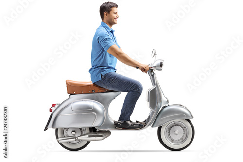 Smiling young man riding a vintage scooter