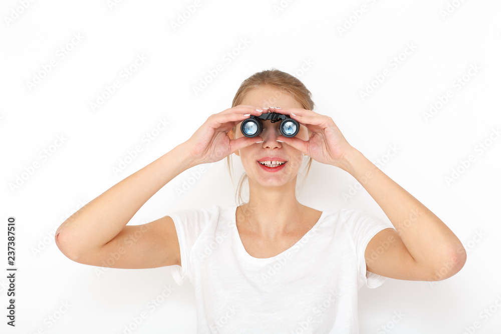Portrait of happy  female model looking through binoculars. Searching gift concept.