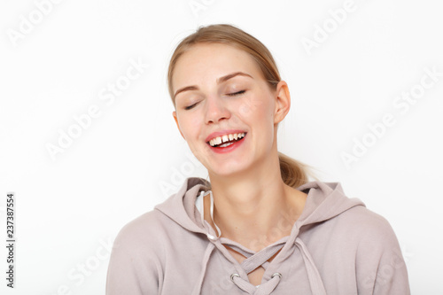 Portrait of laughing happy female model in white background.