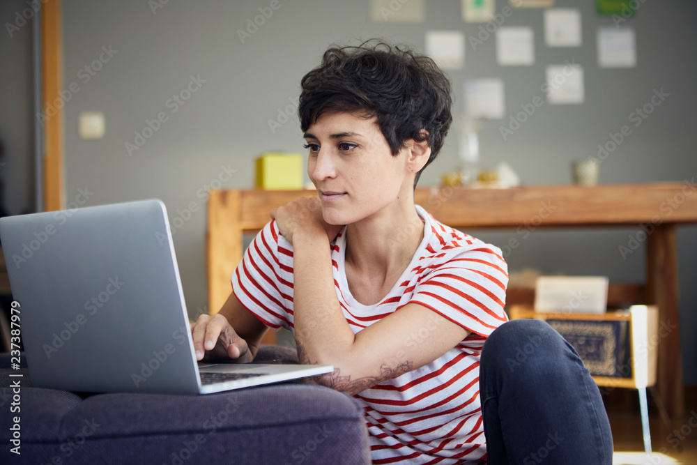 Smiling woman using laptop at home Smiling woman using laptop at home