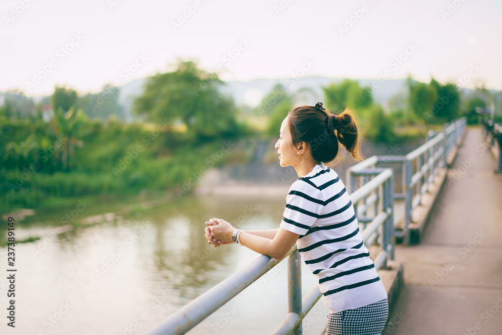woman standing on the bridge in lonely in alone with sunset light in countryside