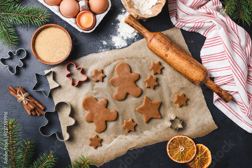 Preparation of gingerbread cookies on black concrete background, top view. Advent Christmas spirit