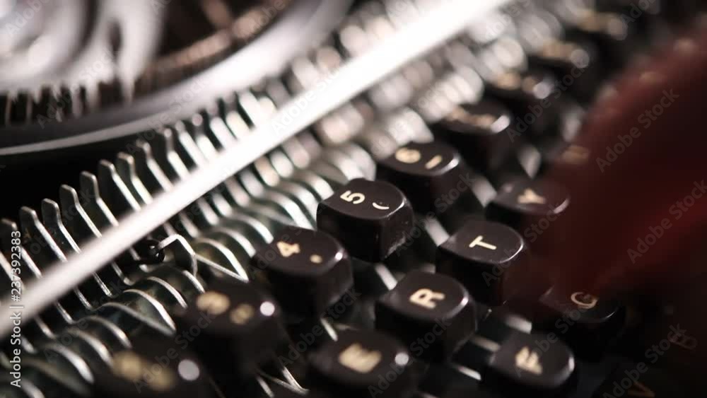 Close up of human hands using vintage typewriter machine selective focus on keyboard