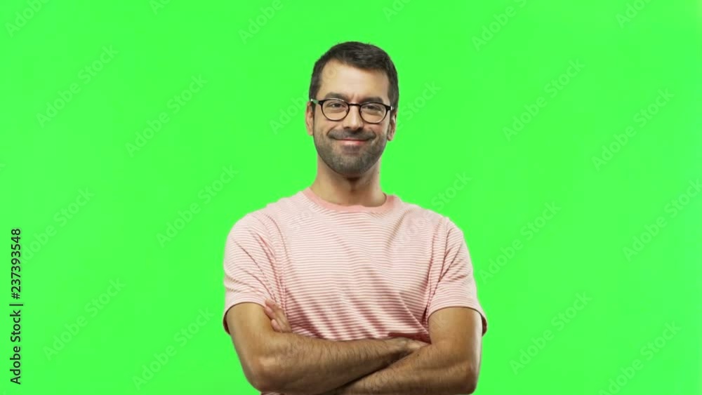 man keeping the arms crossed in confident expression  on green screen chroma key background