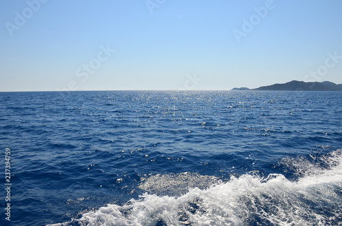 Shining blue Mediterranean sea. View from the yacht. Foamy waves on the water.