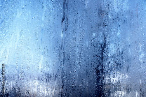Nature background with frozen water drops on window glass