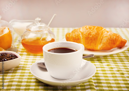 Fresh croissant with cup of coffee on the table.