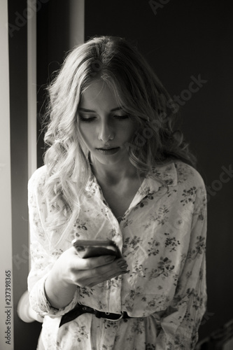 Unhappy young woman using smartphone portrait. Sad girl reading bad news or texting with mobile phone. Family issues, problem concept
