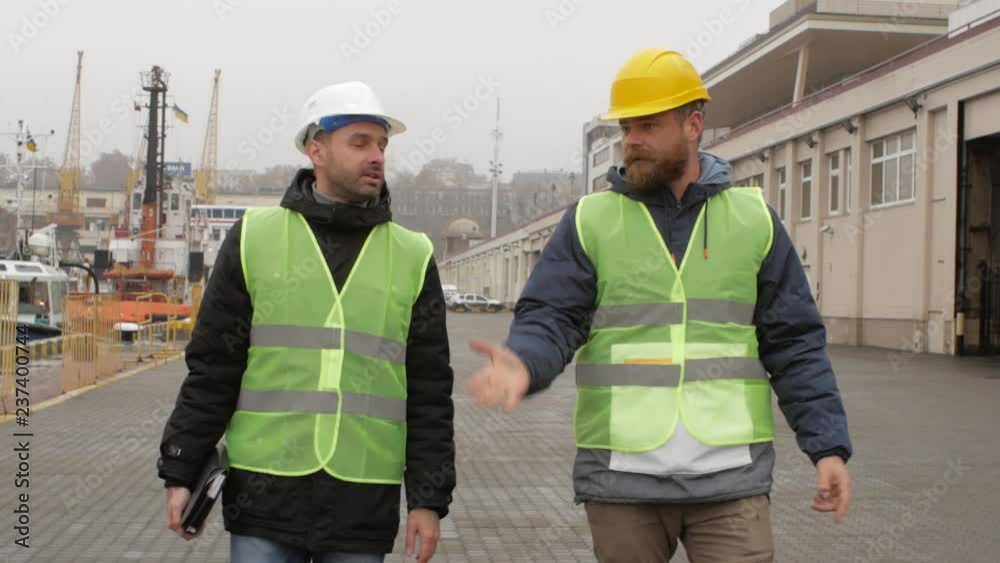 port workers in helmets go to the port and talk port workers in helmets go to the port and talk
