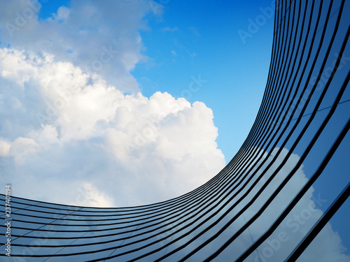 Fototapeta Naklejka Na Ścianę i Meble -  Perspective of high rise building and dark steel window system with clouds reflected on the glass.Business concept of future architecture,lookup to the angle of the building corner. 3d rendering