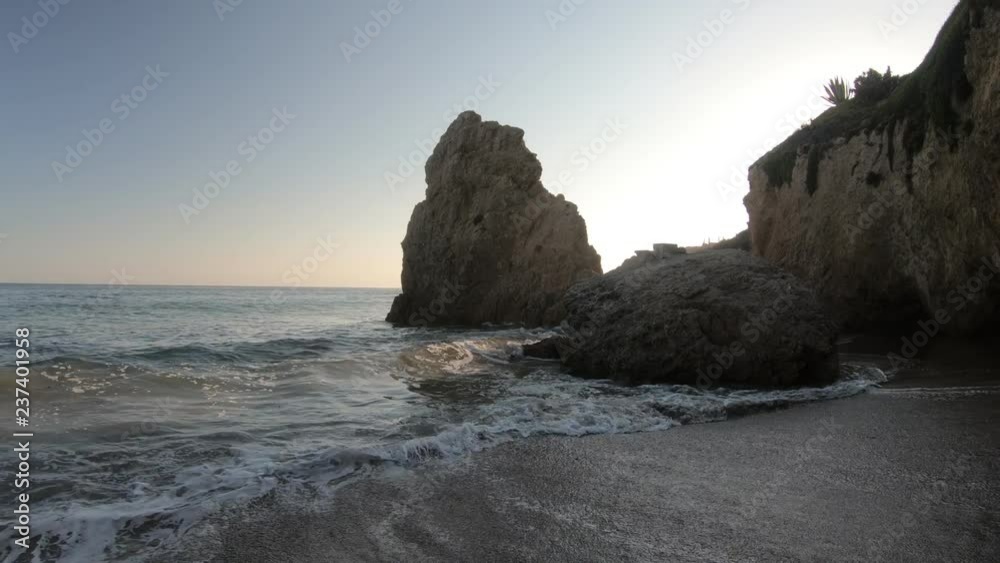 Waves on seashore of El Matador Beach at sunset in Malibu Coast, California, United States. California West Coast. Limeston formations on blurred background. Waves on seashore of El Matador Beach at sunset in Malibu Coast, California, United States. California West Coast. Limeston formations on blurred background.