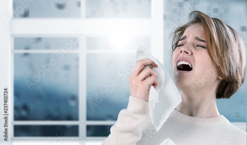 Ill woman with napkin sneezing