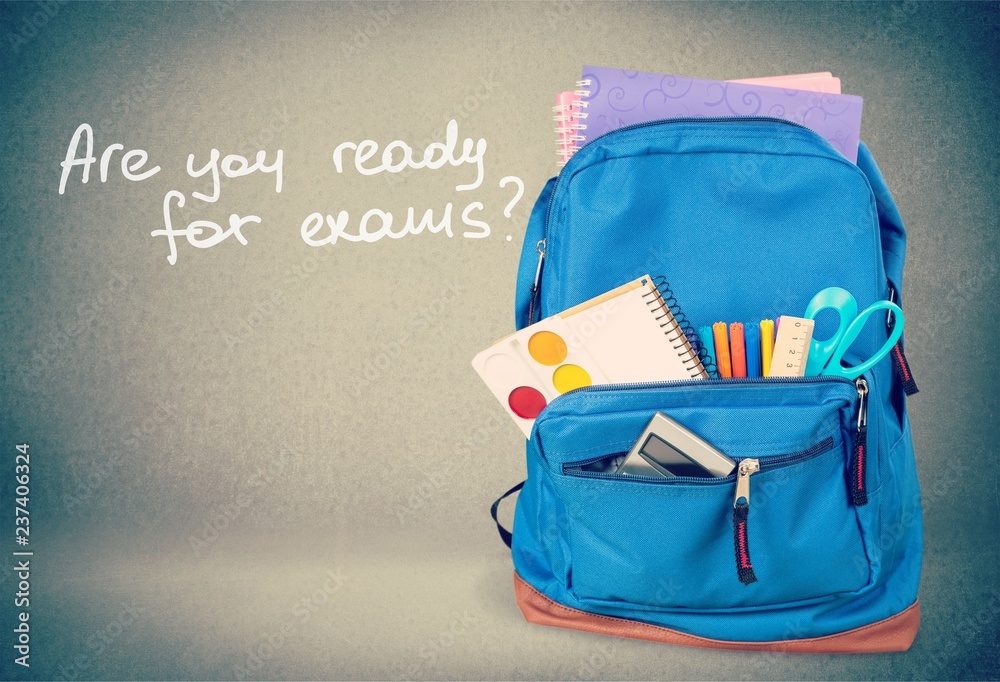 Naklejka premium Colorful school supplies in backpack on wooden background