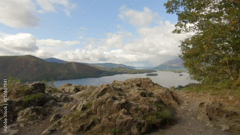Woman stands on a cliff enjoying view of the English Lake District Woman stands on a cliff enjoying view of the English Lake District