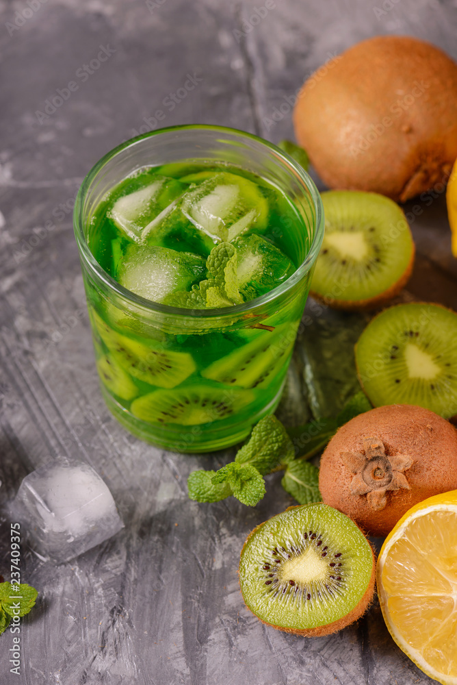 Cocktail with kiwi and mint in a glass on a wooden background. Selective focus. Homemade lemonade with kiwi Cocktail with kiwi and mint in a glass on a wooden background. Selective focus. Homemade lemonade with kiwi