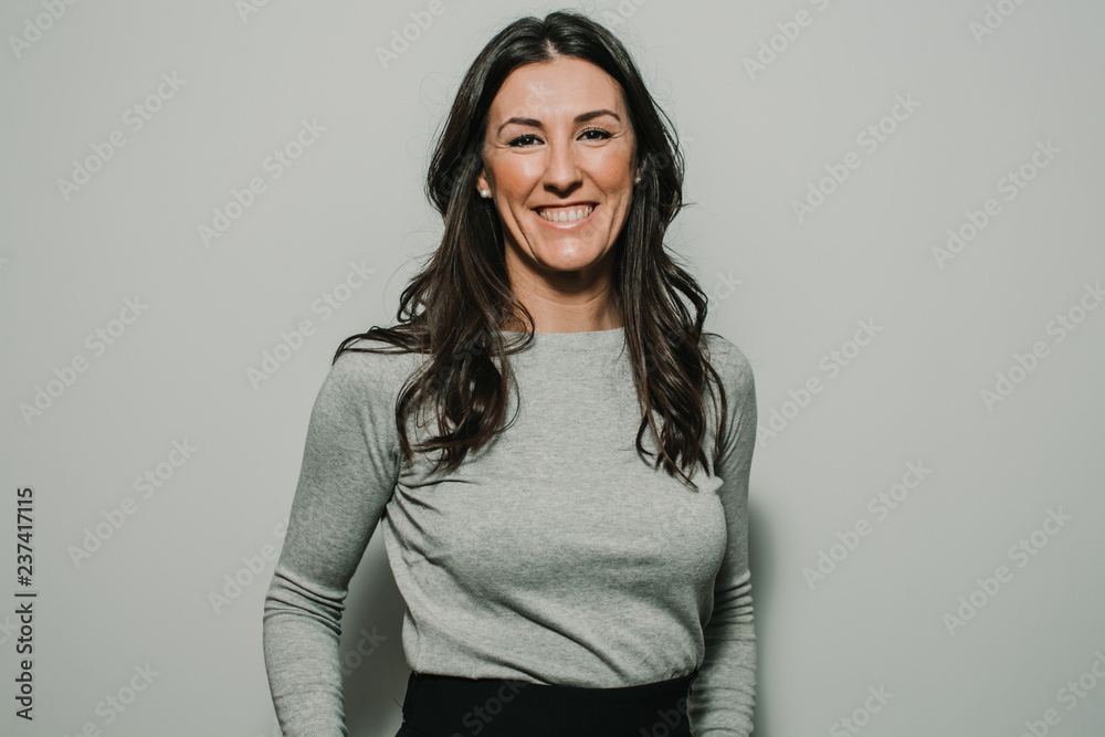 Obraz premium Beautiful, young and successful business woman on gray background with copy space. Confident young manager. Lifestyle.