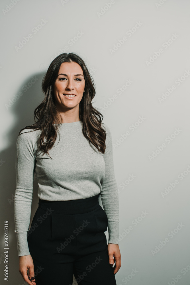 Beautiful, young and successful business woman on gray background with copy space. Confident young manager. Lifestyle. Beautiful, young and successful business woman on gray background with copy space. Confident young manager. Lifestyle.