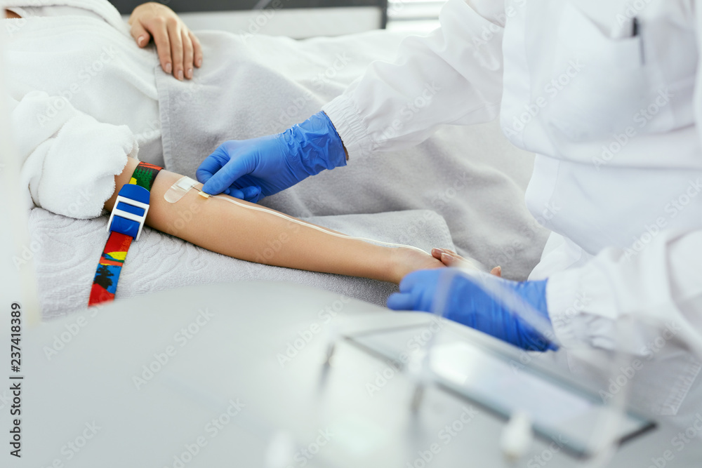 Blood Donation. Doctor Inputting Needle With Dropper In Arm Blood Donation. Doctor Inputting Needle With Dropper In Arm