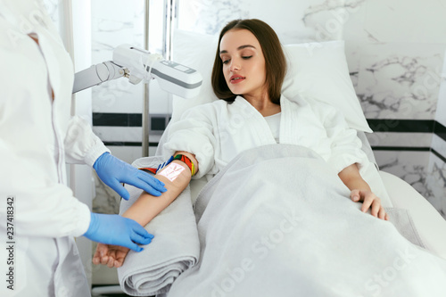 Medical Center. Doctor Scanning Woman Hand With Vein Finder photo