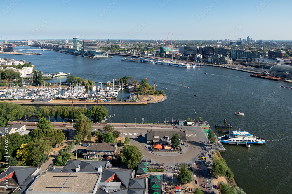 View Dutch harbor Amsterdam with marina, ferry and apartment buildings