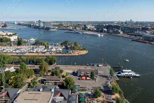 Photography View Dutch harbor Amsterdam with marina, ferry and apartment buildings
