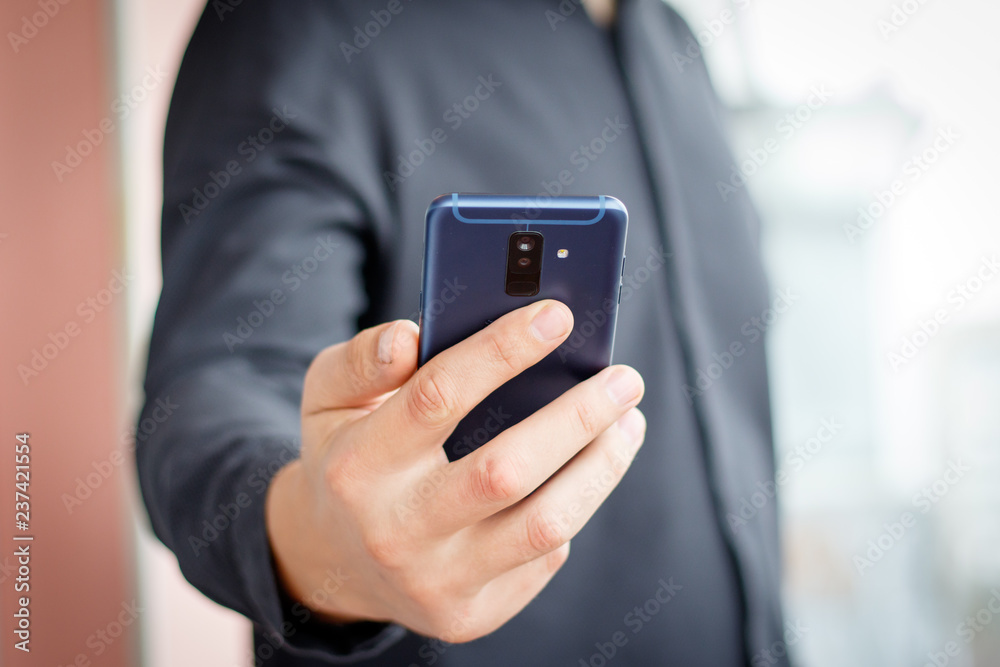 Male hand holding a cell smartphone and writing sms