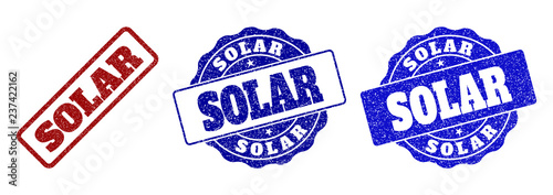 SOLAR scratched stamp seals in red and blue colors. Vector SOLAR watermarks with grunge texture. Graphic elements are rounded rectangles, rosettes, circles and text labels. photo