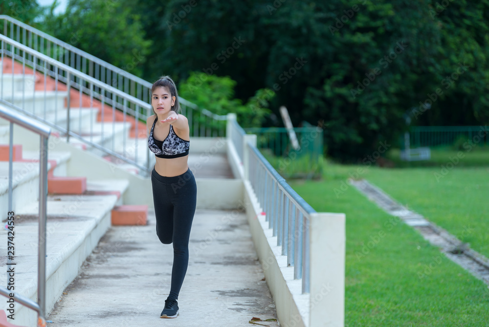 Asian sporty woman stretching body breathing fresh air in the park,Thailand people,Fitness and  exercise concept,Jogging in the park