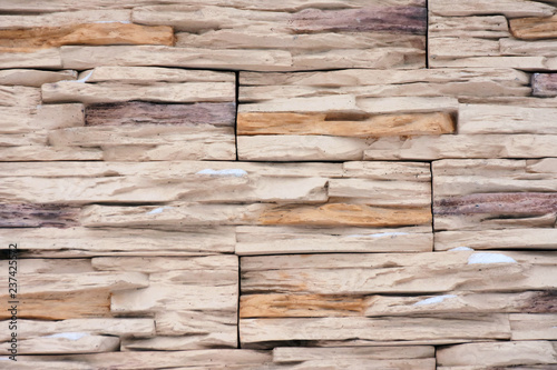 Background with old brick wall of aged bricks. Natural beige stone surface with rough texture and selective focus. Decorate abstract wallpaper with structure granite rocks.