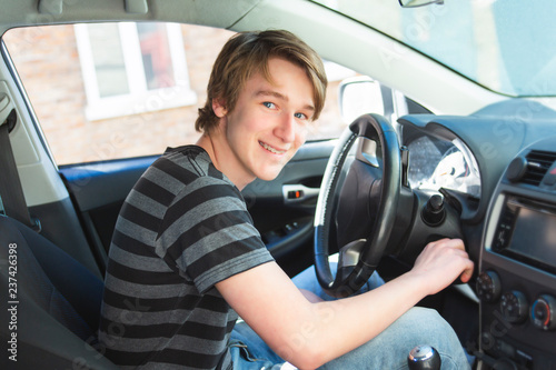A Teenage boy and new driver behind wheel of his car photo