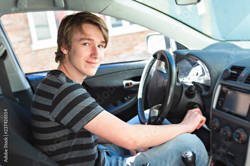 A Teenage boy and new driver behind wheel of his car photo