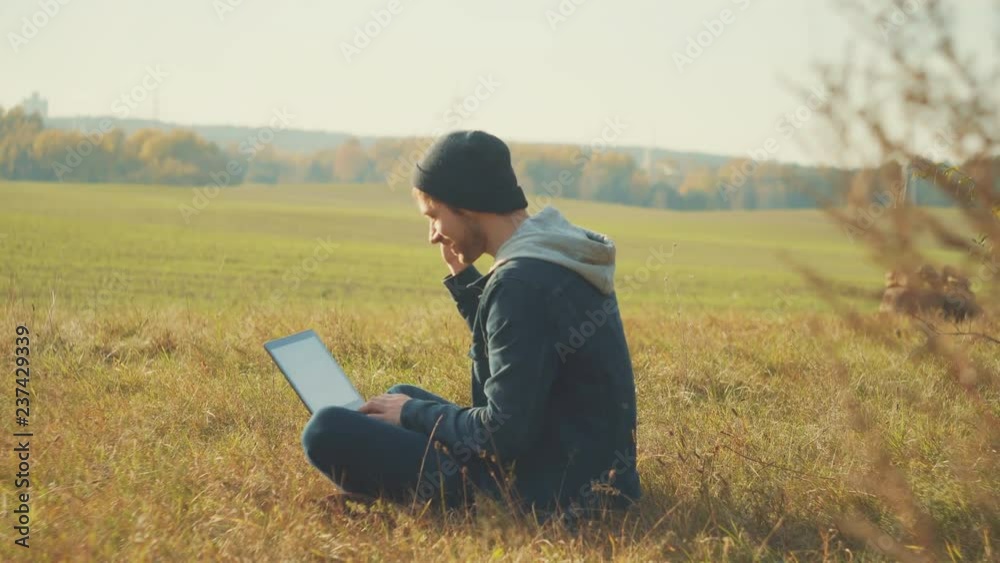 Portrait shot of the young handsome hiker having video chat on his laptop in the beautiful green forest. Outside Portrait shot of the young handsome hiker having video chat on his laptop in the beautiful green forest. Outside