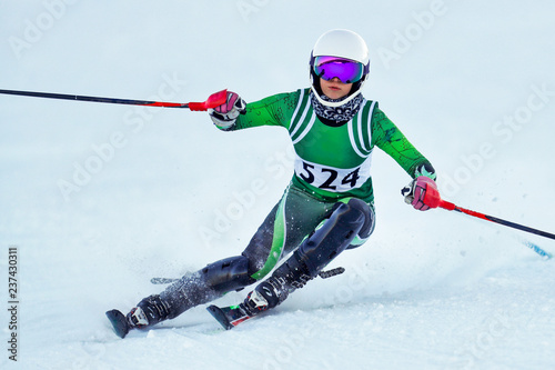 An alpine ski racer rounding a gate during a race.