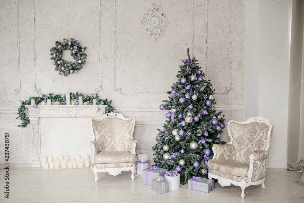 a christmas environment: a tree with purple toys, two vintage armchairs and a white fireplace