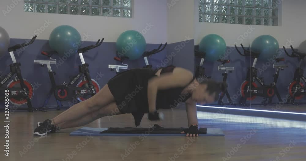 Mujer en gimnasio haciendo deporte con pesas