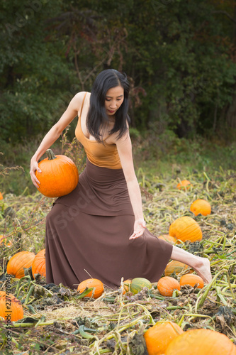 Adult woman dancing in a Connecticut pumpkin patch in autumn.
