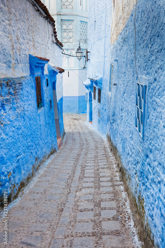 long narrow street in blue city in Morocco © sergejson