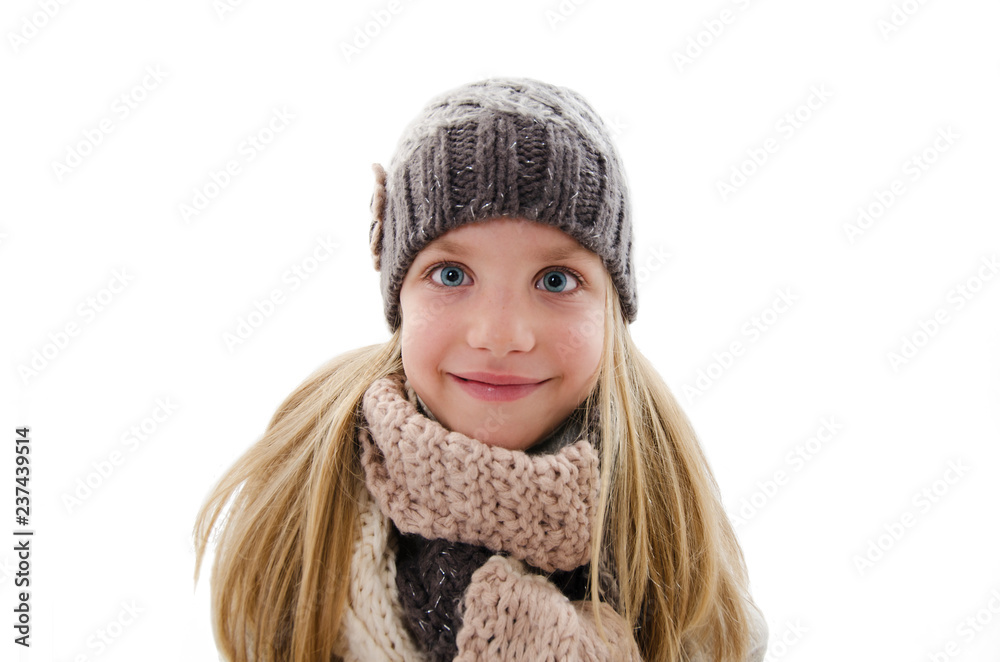 Beautiful little girl in cap and scarf. Winter style Isolated on white background