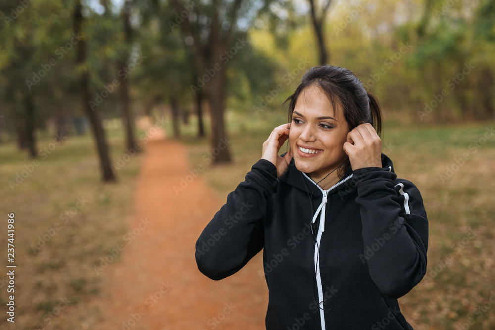 Portrait of young sports woman preparing for training in park Portrait of young sports woman preparing for training in park