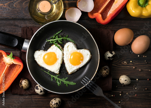 Fried eggs on a skillet on a wooden background