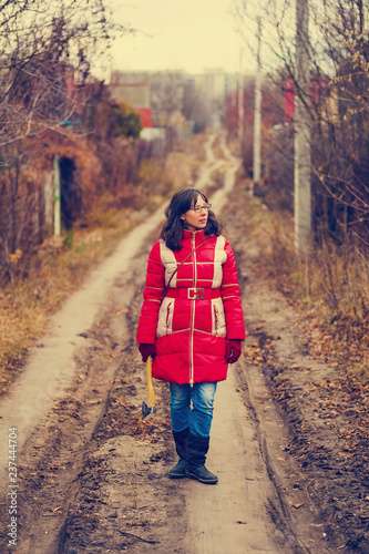 strong woman with hatchet standing on a rural road