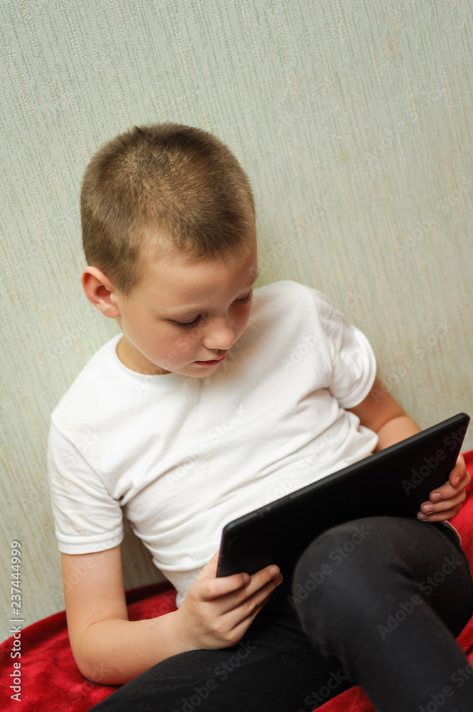 kid hold a digital tablet and looking kid hold a digital tablet and looking
