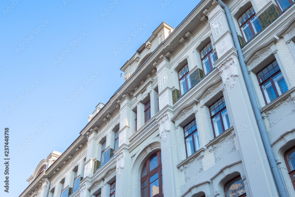 Beautiful facade of an old building with lots of windows, against a blue sky